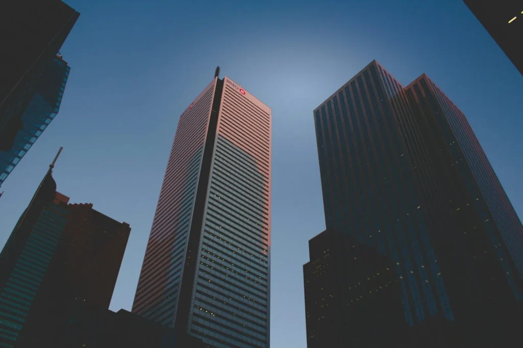Looking up at high-rise office towers against a bright sky